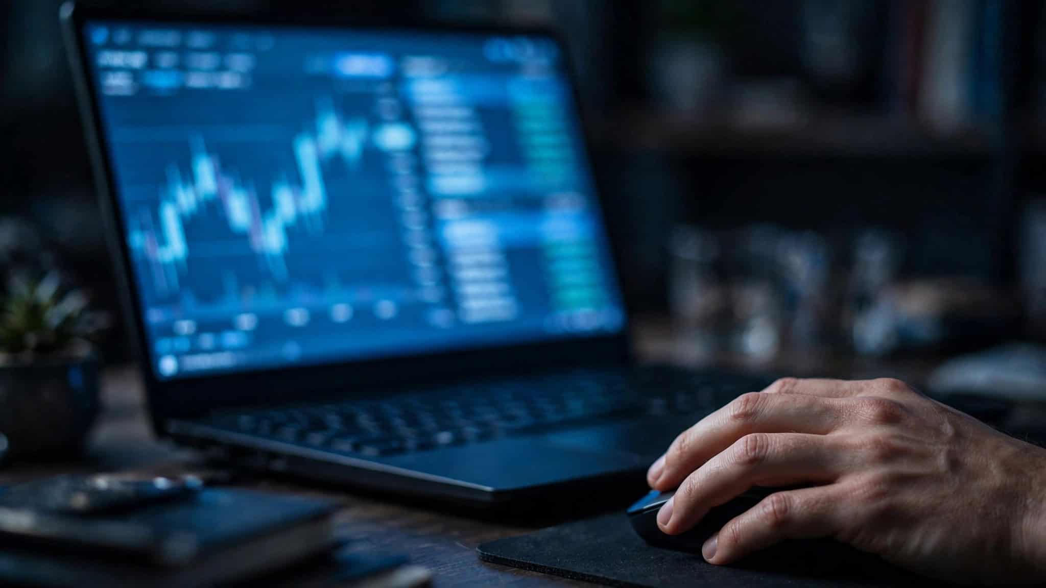 Close-up of a trading interface on a laptop with a depth-of-market ladder, hand on a mouse